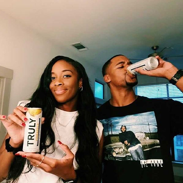 Couple drinking cans of Truly Hard Seltzer