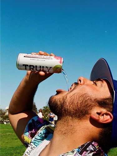 Man pouring can of Truly into his mouth